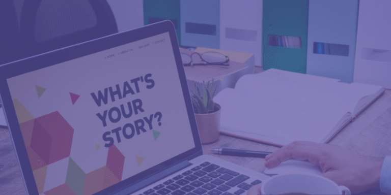 Pessoa com um computador portátil aberto que exibe a mensagem “What’s your story?”, sobre uma secretária com caderno, chávena, óculos e pastas de arquivo ao fundo.