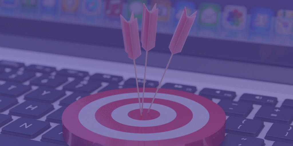 Alvo com três setas cravadas no centro sobre teclado de computador, representando precisão e foco em marketing digital.